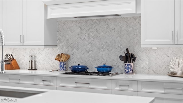 kitchen with backsplash and white cabinetry