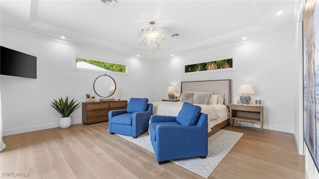 bedroom featuring a raised ceiling, light hardwood / wood-style flooring, and crown molding