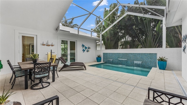 view of swimming pool with french doors, pool water feature, a patio, and a lanai