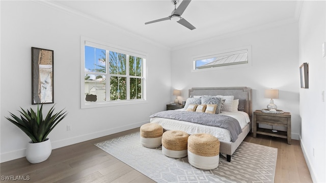 bedroom featuring hardwood / wood-style floors, ceiling fan, and crown molding