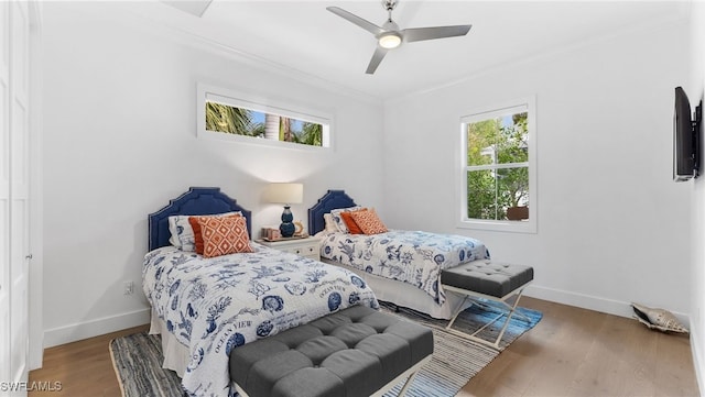 bedroom featuring ceiling fan, crown molding, and wood-type flooring