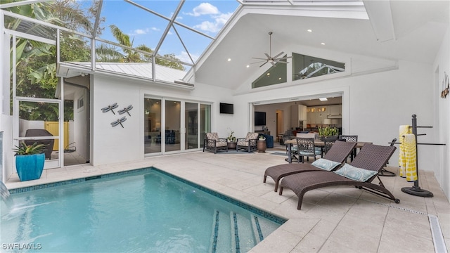 rear view of house featuring glass enclosure, ceiling fan, pool water feature, and a patio