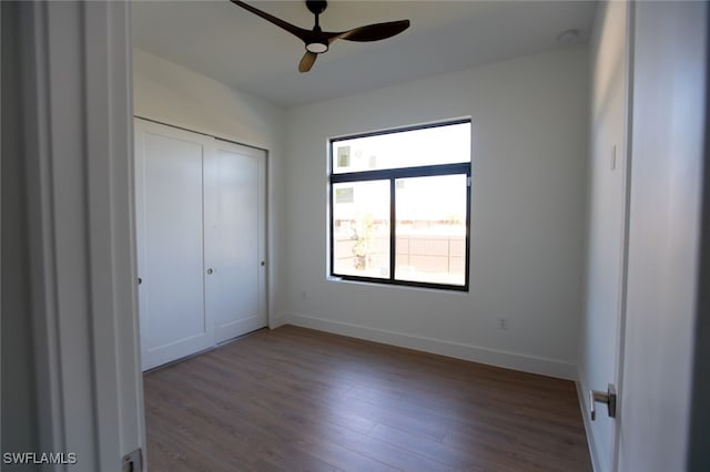 unfurnished bedroom featuring wood-type flooring, ceiling fan, and a closet