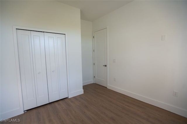 unfurnished bedroom featuring dark hardwood / wood-style floors and a closet