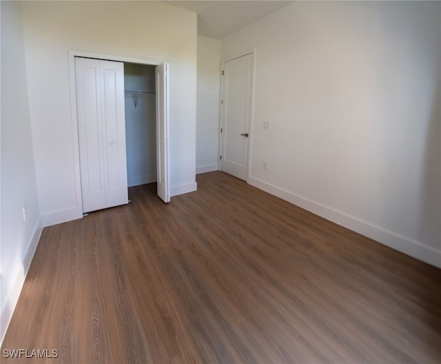 unfurnished bedroom featuring dark hardwood / wood-style floors and a closet