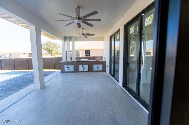 view of patio with ceiling fan and a fenced in pool