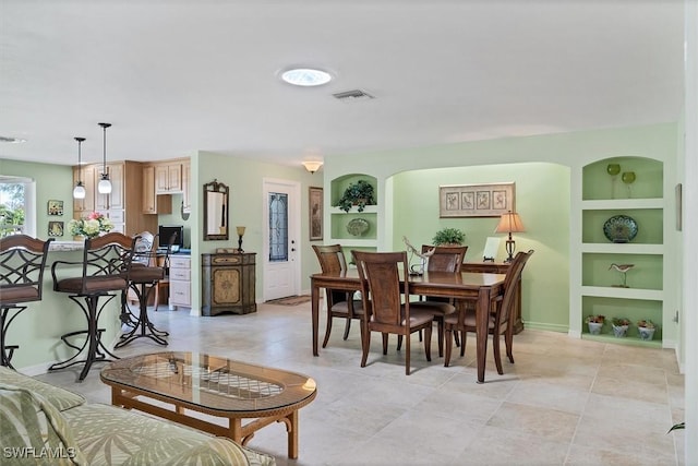 tiled dining area featuring built in shelves