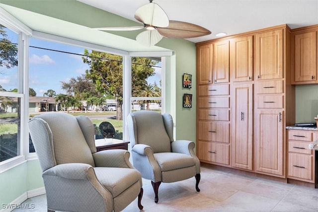 sitting room with ceiling fan and light tile patterned flooring