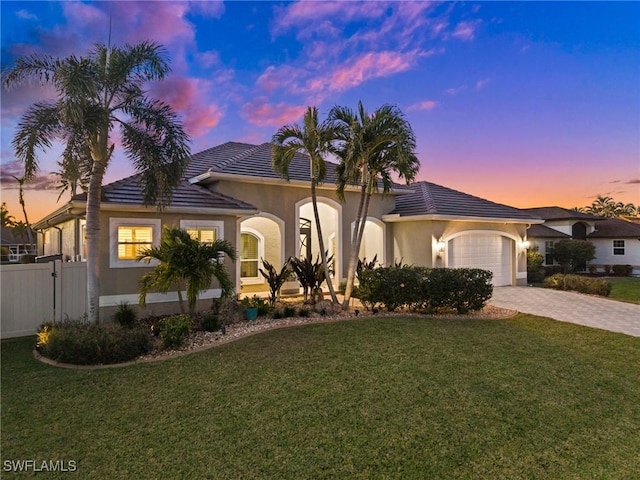 mediterranean / spanish house featuring a lawn and a garage