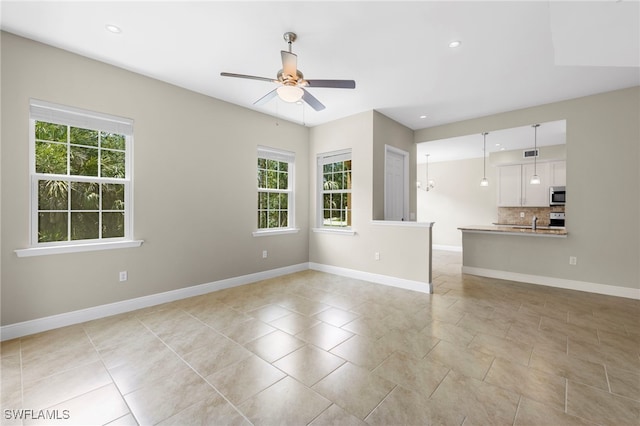 unfurnished living room featuring sink, ceiling fan, and light tile patterned flooring