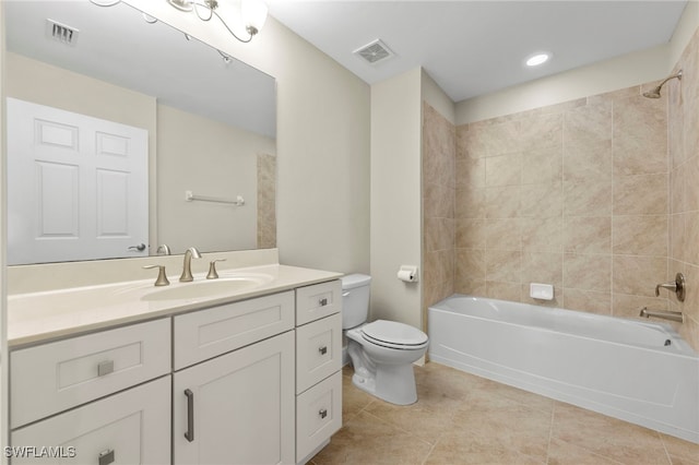 full bathroom with tile patterned flooring, vanity, tiled shower / bath combo, and toilet