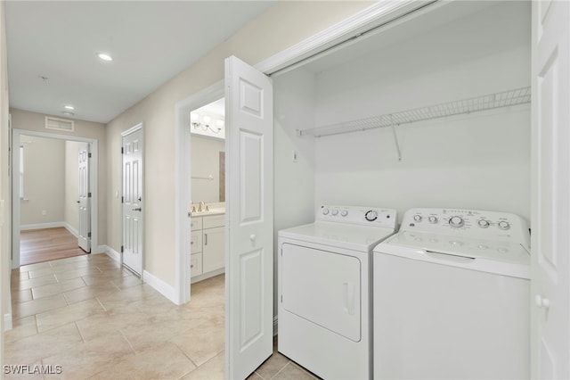 washroom featuring sink, light tile patterned floors, and independent washer and dryer