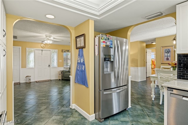 kitchen with ceiling fan, backsplash, a textured ceiling, white cabinets, and appliances with stainless steel finishes