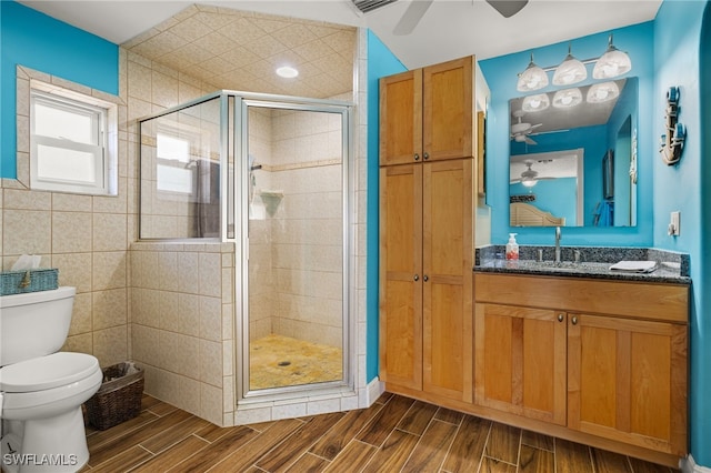 bathroom featuring walk in shower, vanity, tile walls, and toilet