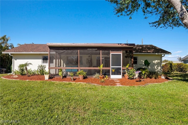 back of property featuring a sunroom and a yard