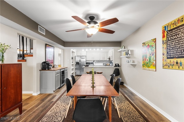 dining space with wine cooler, ceiling fan, and dark wood-type flooring