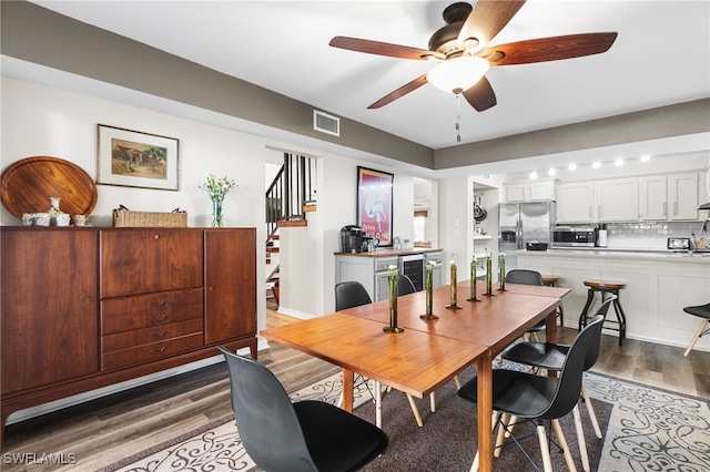 dining space featuring ceiling fan, wood-type flooring, and beverage cooler