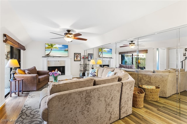 living room featuring wood-type flooring, vaulted ceiling, and ceiling fan