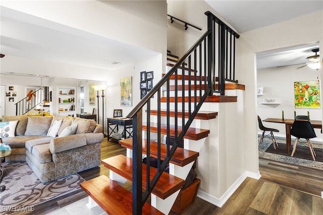 staircase featuring ceiling fan and wood-type flooring