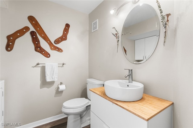 bathroom featuring vanity, wood-type flooring, and toilet