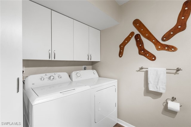 washroom featuring washing machine and clothes dryer and cabinets