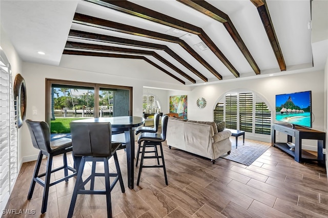 dining room with hardwood / wood-style floors and lofted ceiling with beams