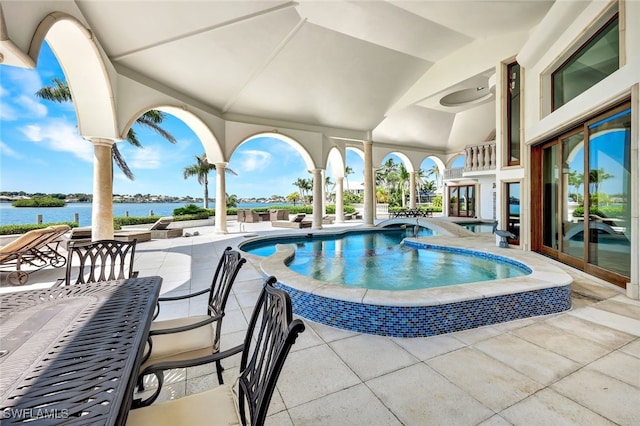 view of pool with a water view and a patio