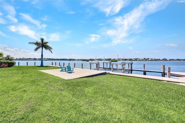 view of dock with a lawn and a water view