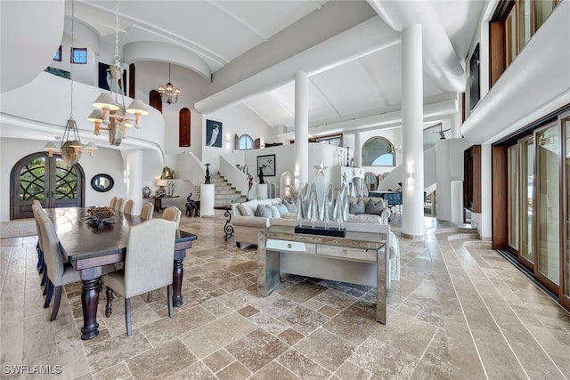 dining room featuring french doors, high vaulted ceiling, and an inviting chandelier