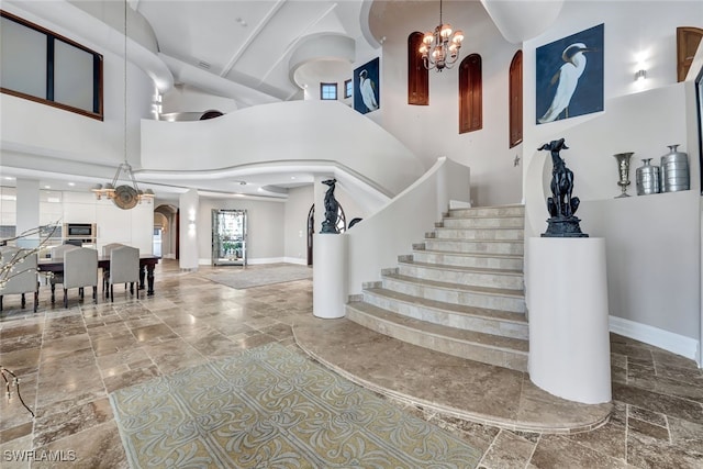 stairs with a chandelier and a towering ceiling