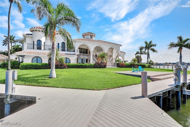 view of dock with a yard, a balcony, and a water view