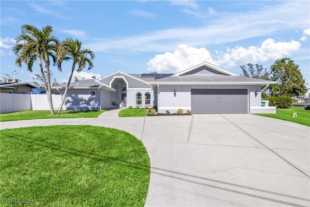 ranch-style house featuring solar panels, a garage, and a front lawn