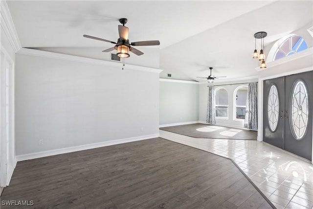 foyer entrance featuring lofted ceiling, crown molding, dark wood-type flooring, and french doors