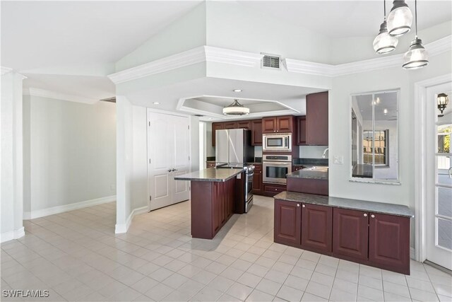 kitchen with lofted ceiling, appliances with stainless steel finishes, hanging light fixtures, a center island, and a raised ceiling