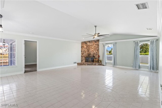 unfurnished living room with ceiling fan, lofted ceiling, a stone fireplace, and ornamental molding