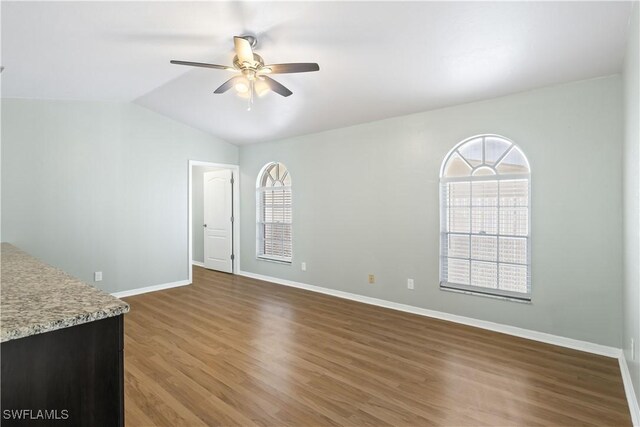 unfurnished living room featuring ceiling fan, lofted ceiling, and dark hardwood / wood-style flooring