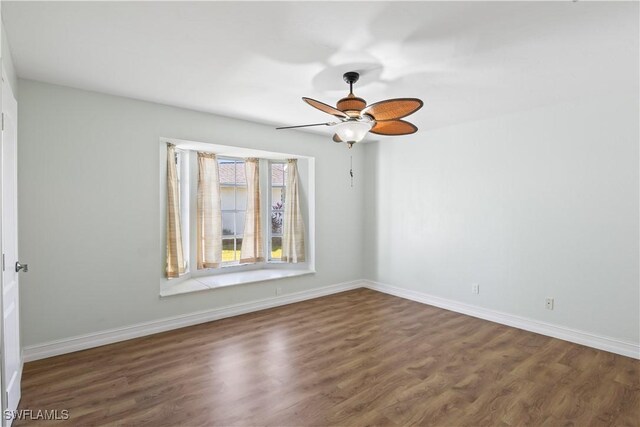 empty room with dark hardwood / wood-style flooring and ceiling fan