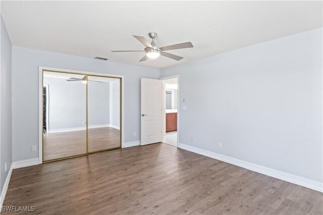 unfurnished bedroom with wood-type flooring, a closet, and ceiling fan