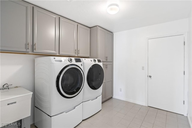 washroom with cabinets, sink, and washing machine and clothes dryer