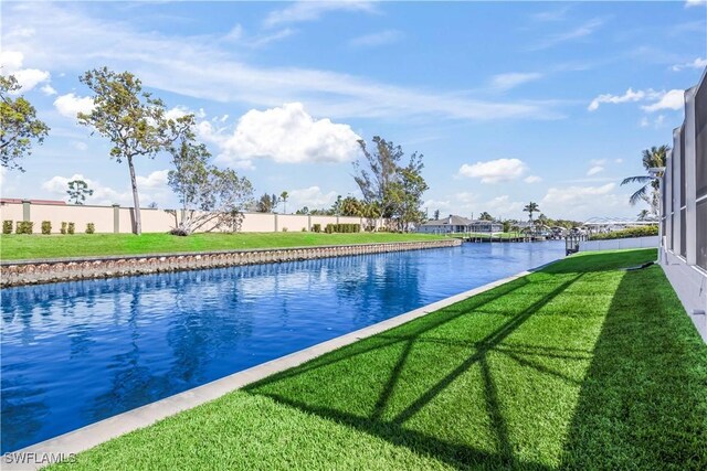 view of swimming pool with a water view and a yard