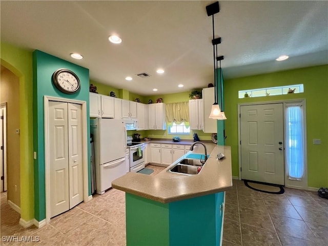 kitchen with pendant lighting, white appliances, white cabinetry, and sink