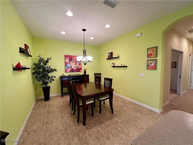 tiled dining room featuring a notable chandelier