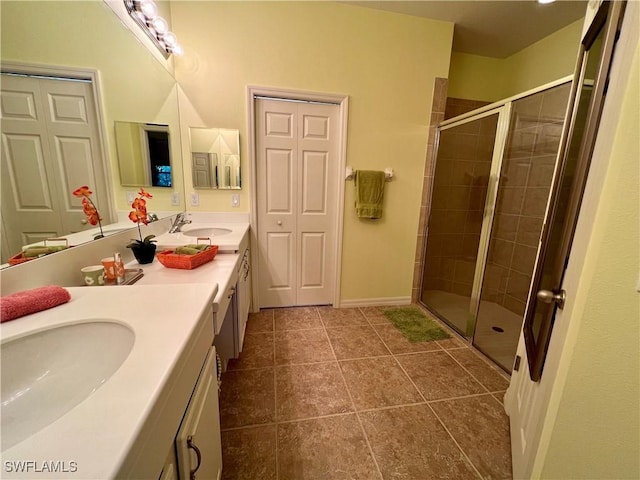 bathroom featuring tile patterned floors, a shower with door, and vanity