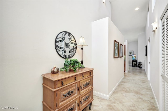 hall featuring a high ceiling and light tile patterned floors