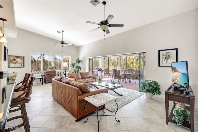 living room with ceiling fan, lofted ceiling, and light tile patterned flooring