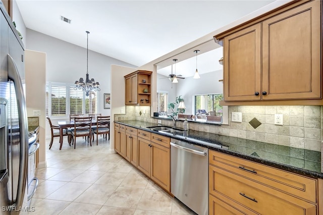 kitchen with pendant lighting, ceiling fan with notable chandelier, appliances with stainless steel finishes, and lofted ceiling