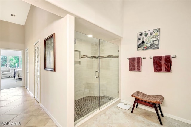 bathroom featuring a towering ceiling, tile patterned flooring, and an enclosed shower