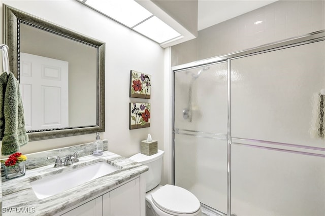 bathroom with toilet, a shower with shower door, and vanity