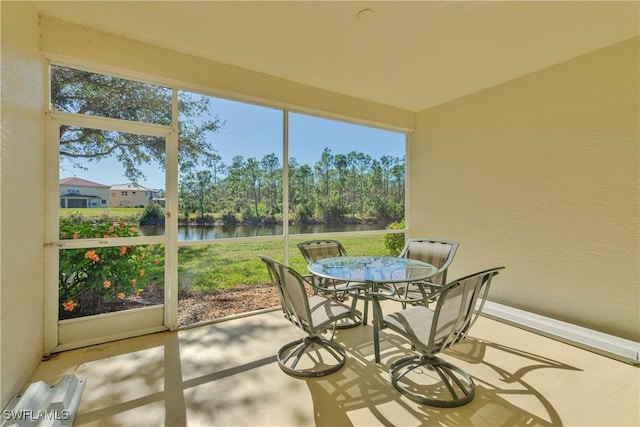 sunroom / solarium featuring a water view