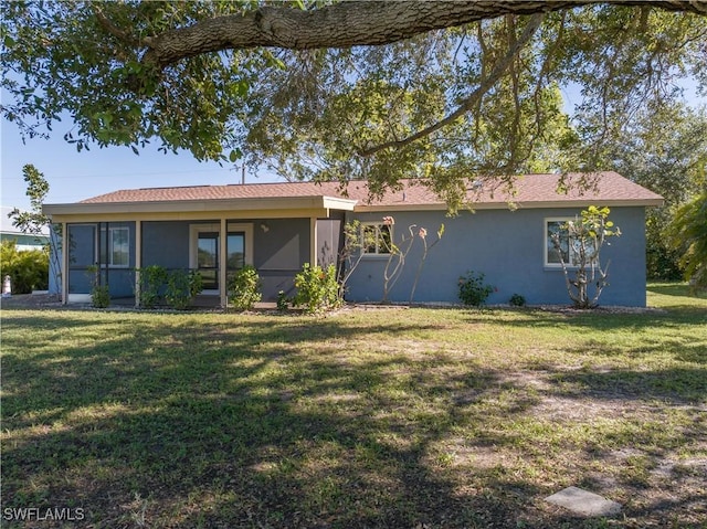 view of front of property featuring a sunroom and a front lawn